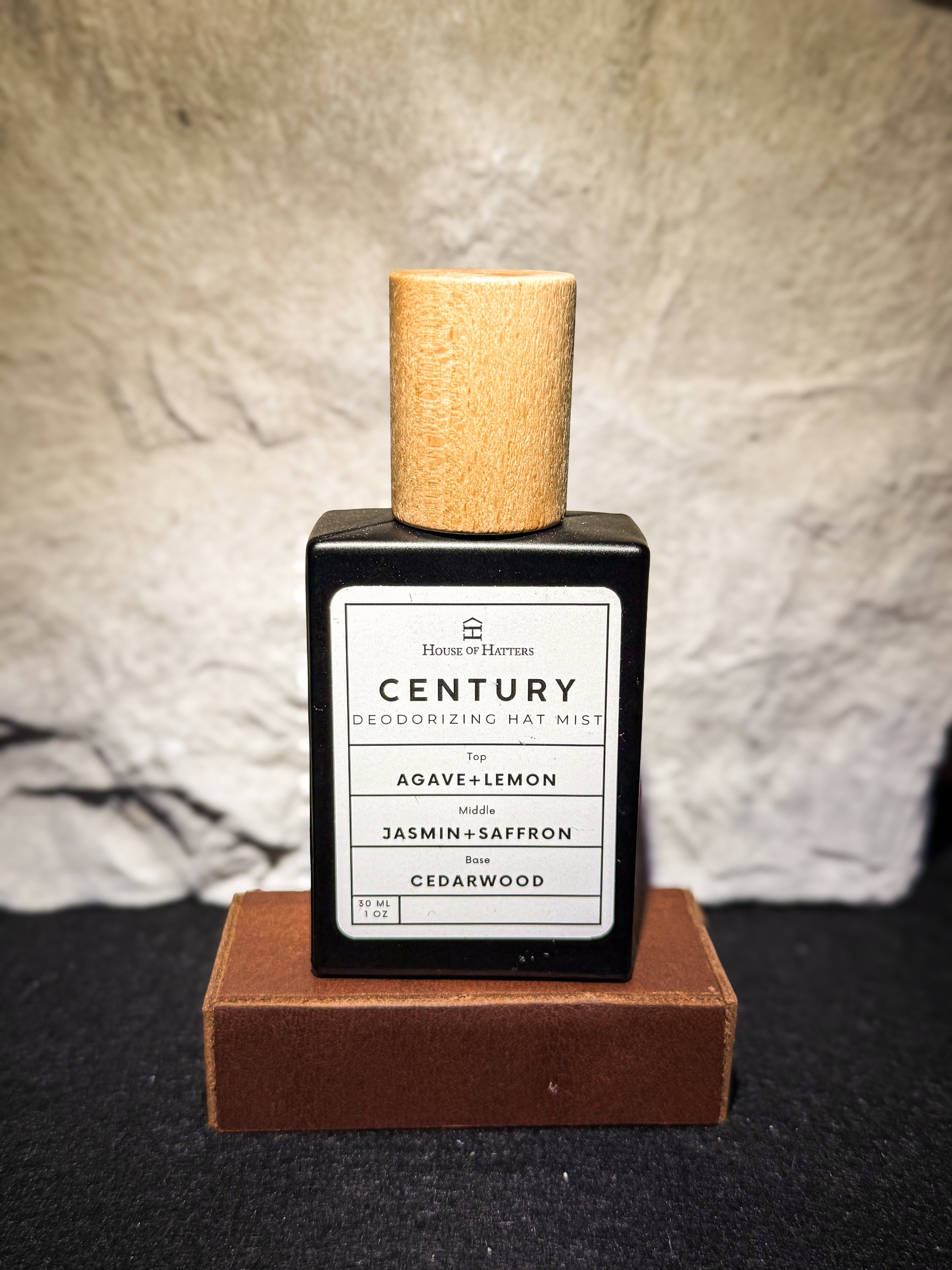Deodorizing hat mist bottle with cork cap on a textured surface