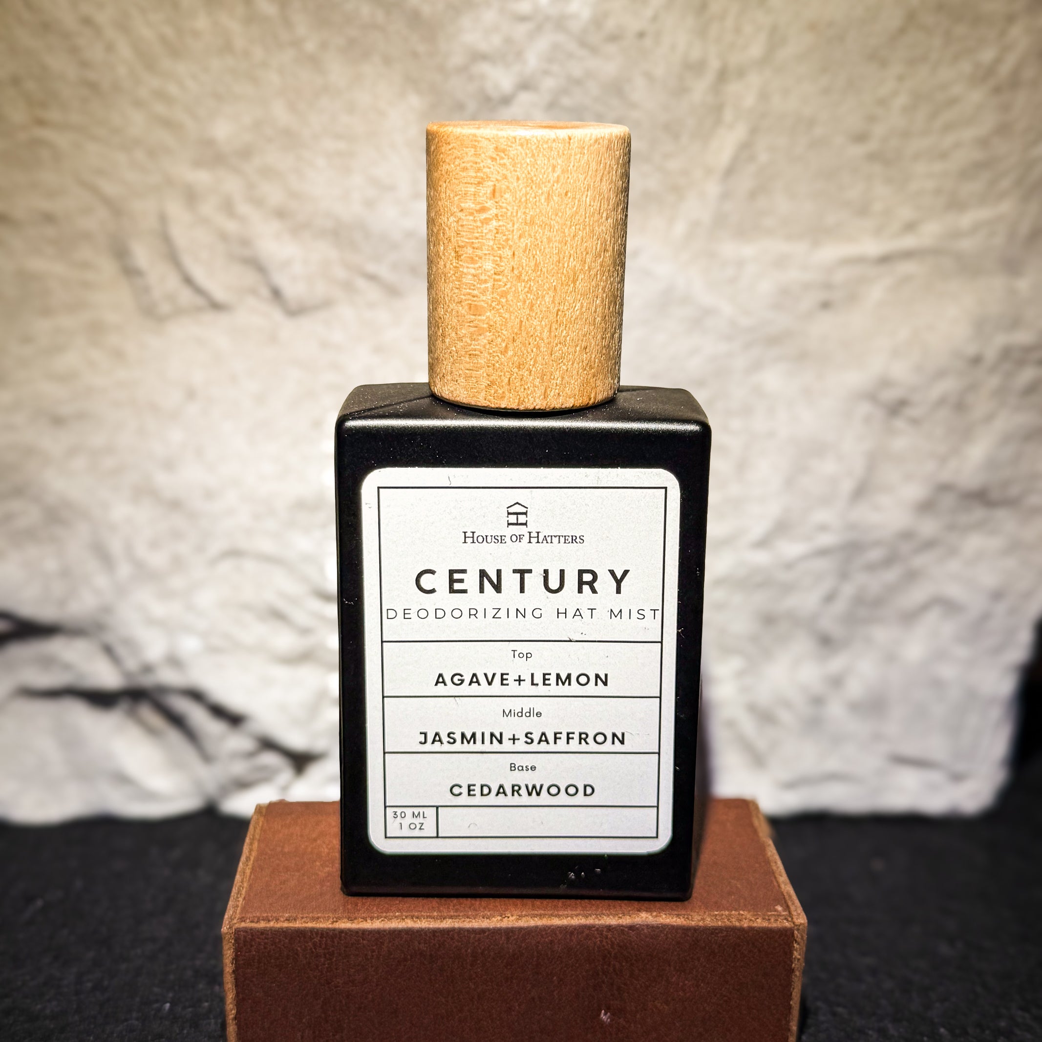 Deodorizing hat mist bottle with cork cap on a textured surface