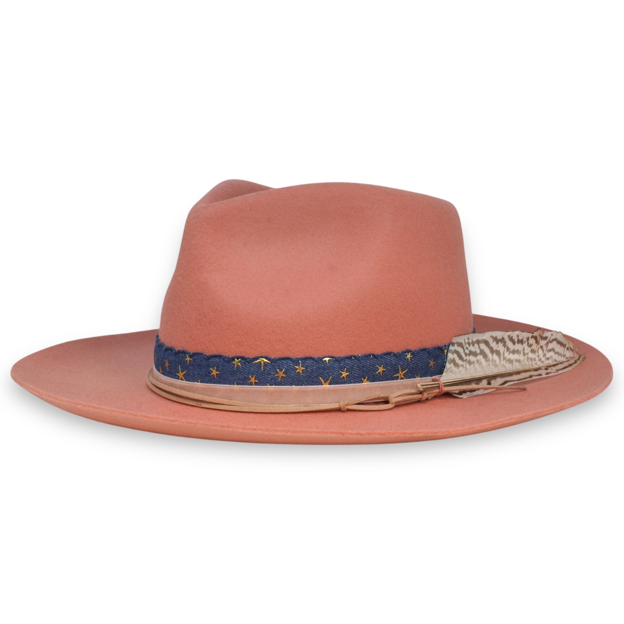 A coral pink fedora with a lifted brim, star ribbon, pink velvet ribbon, a leather hat tie, and a large feather created by House of Hatters.