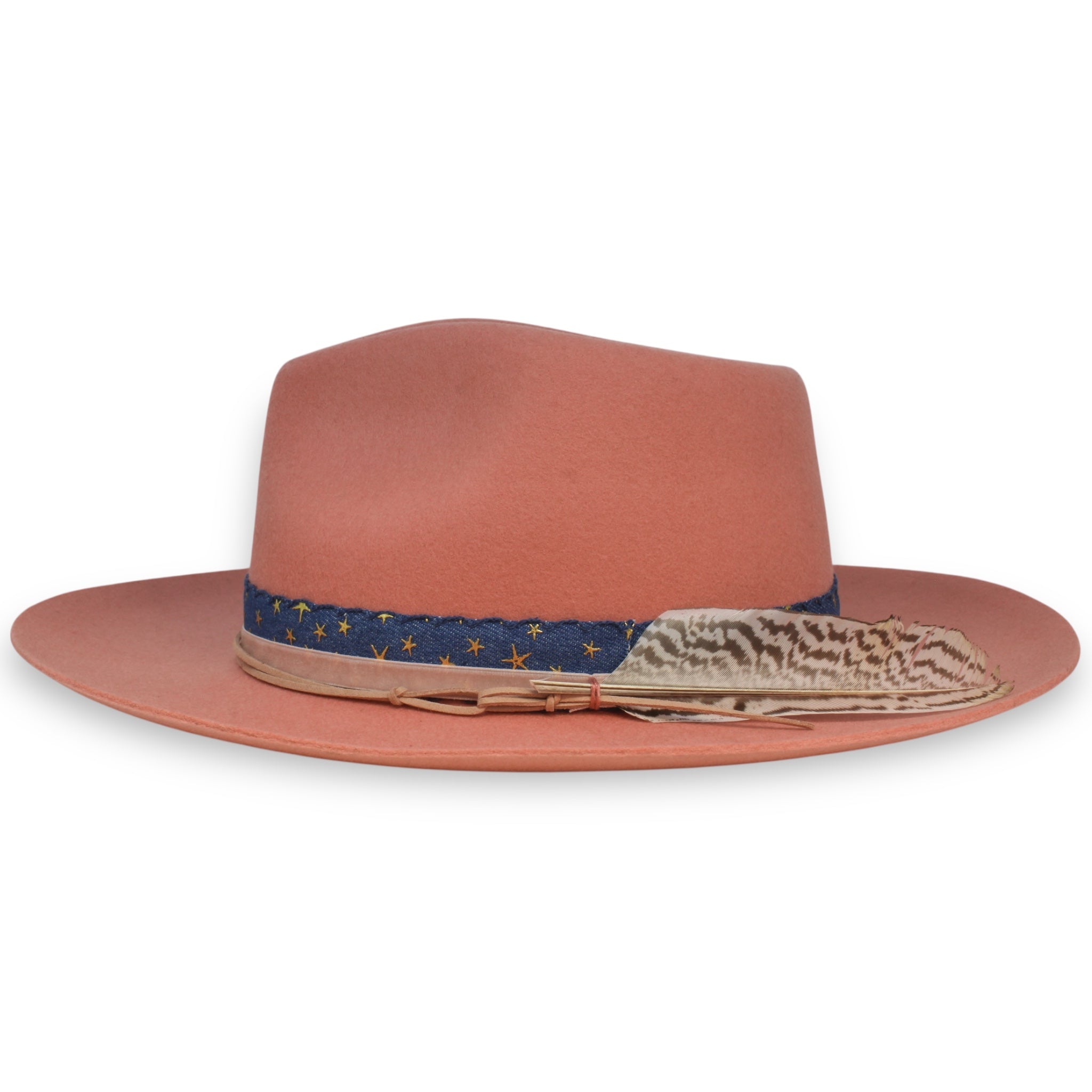 Side profile of a pink hat featuring a white and brown striped feather.