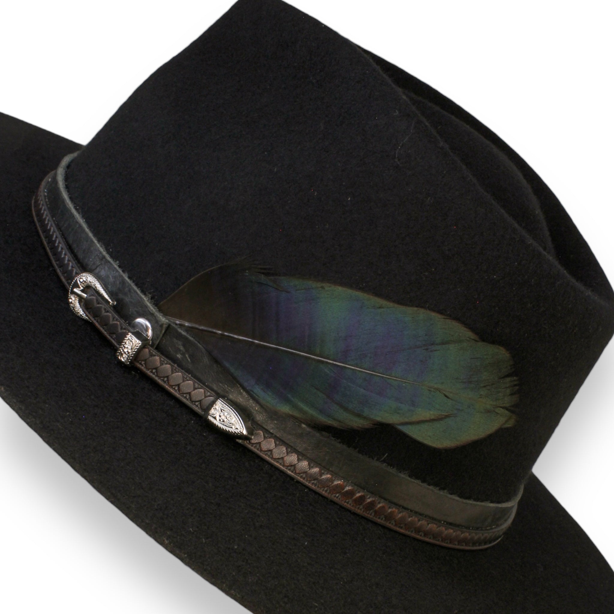 A close up of the black fedora with two leather bands and a feather. The sheen of the feather is present--showing off the blue and dark cyan color.