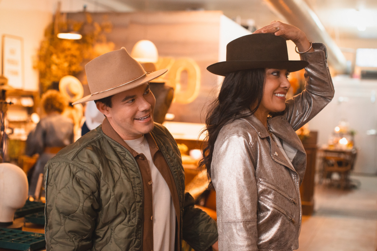 Hatter and customer smiling while trying on a personalized hat at the House of Hatters custom hat bar