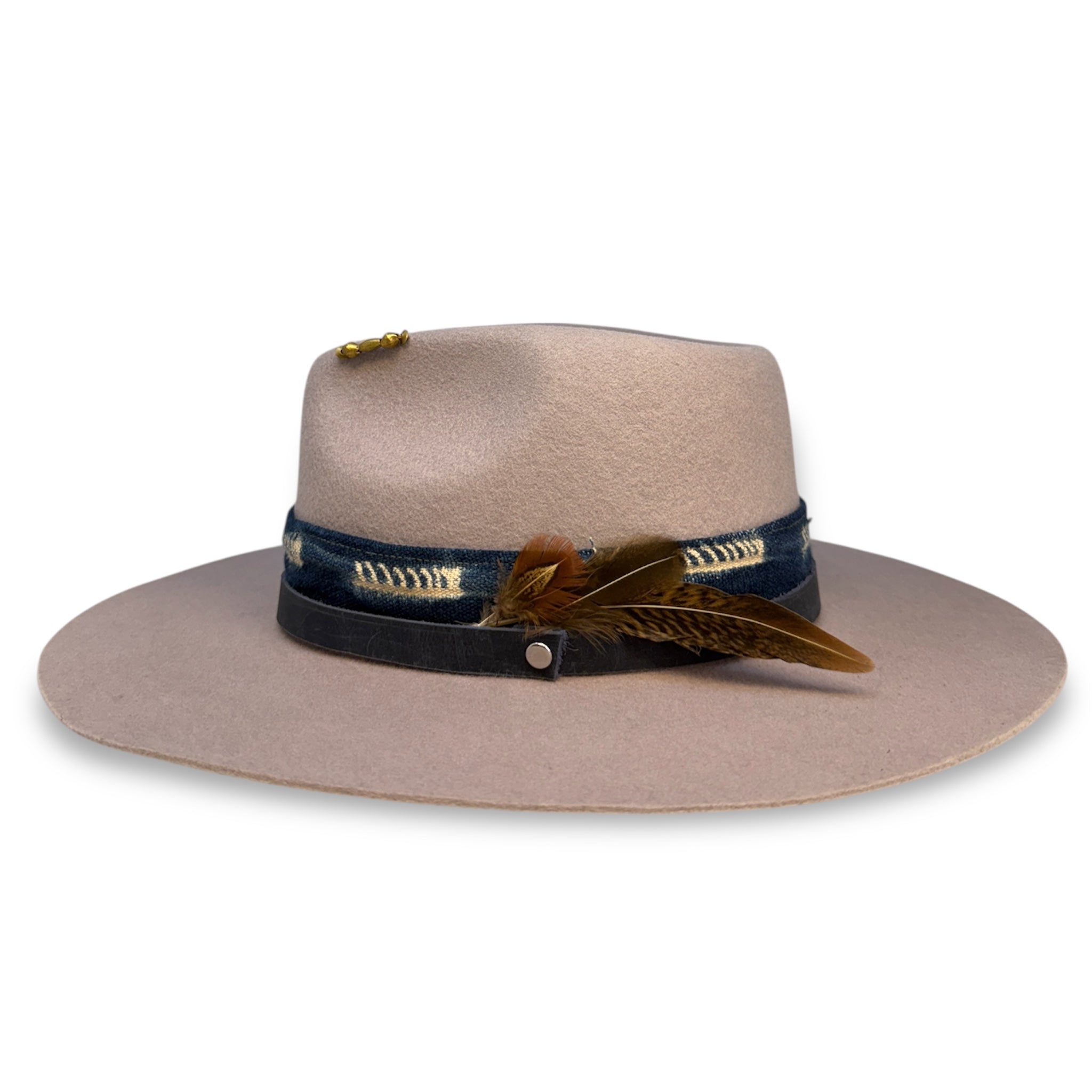 Side profile of a pale purple felt hat, a blue and white textile band, a blue leather hat band, and a feather pin of three small and medium sized feathers.