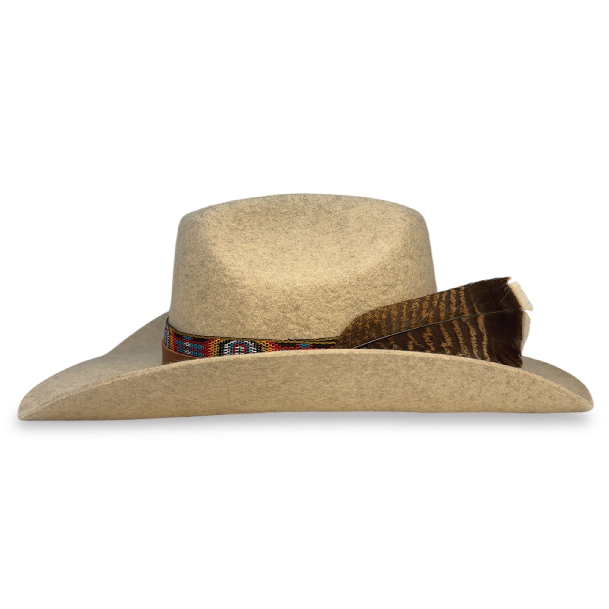 Side view of custom oatmeal felt cowboy hat showing the wings of the hat and the turkey feather.