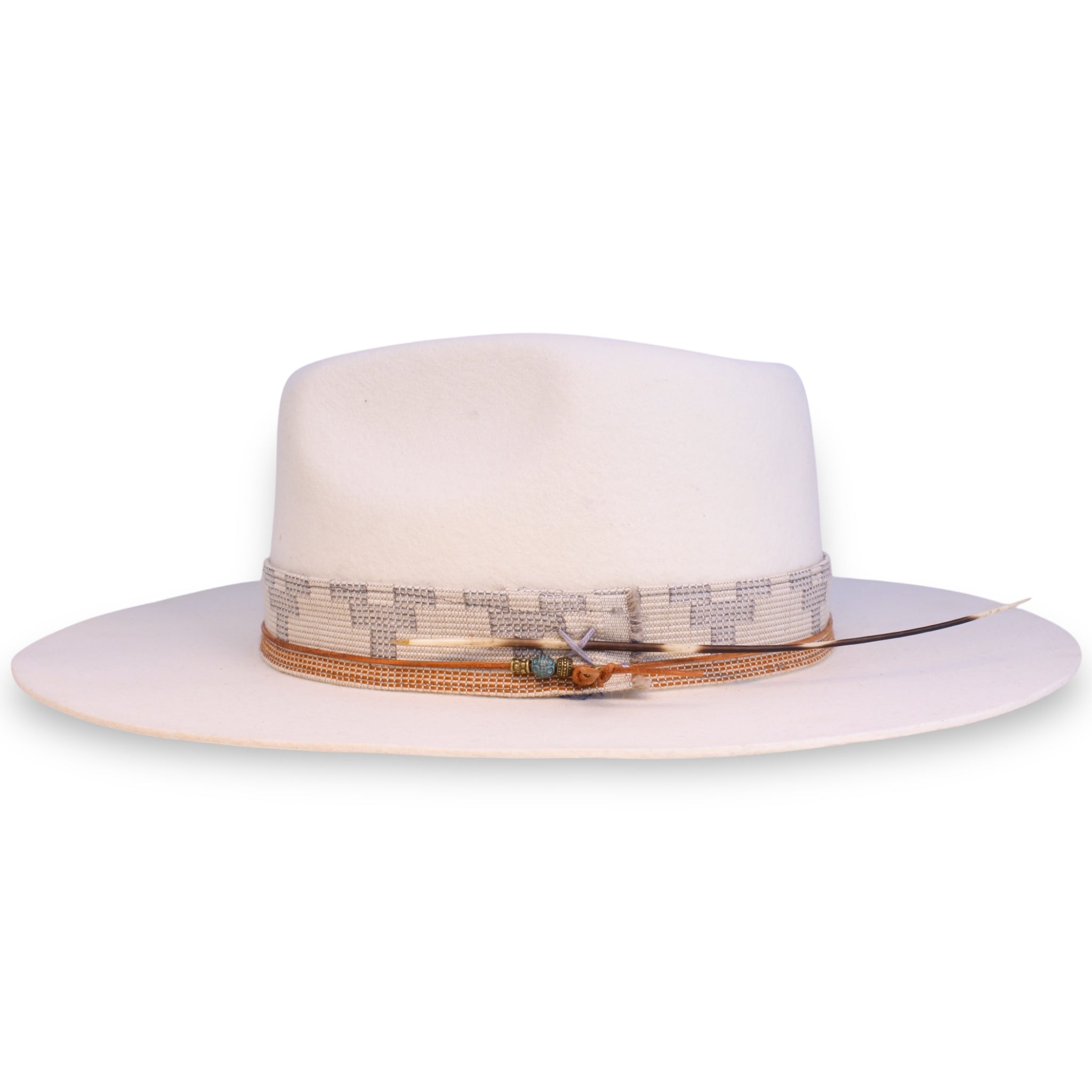 The side view of a flat brim fedora with a textile band, an intricate hat tie with brass and turquoise beads, and a porcupine quill.
